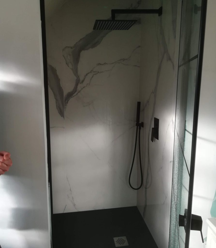 Coin douche : Vue rapprochée d'une robinetterie de douche noire.