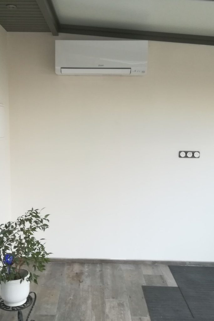 Mur épuré : Unité de climatisation blanche sur mur blanc.